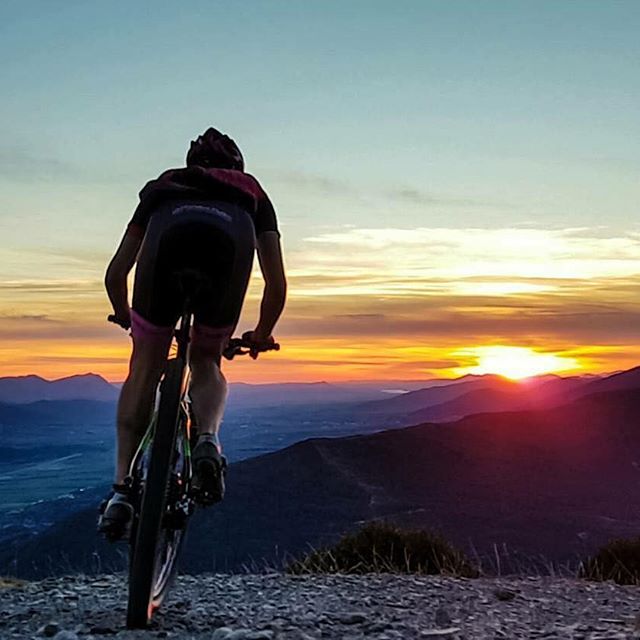 Ciclista de carretera al atardecer en un puerto de montaña