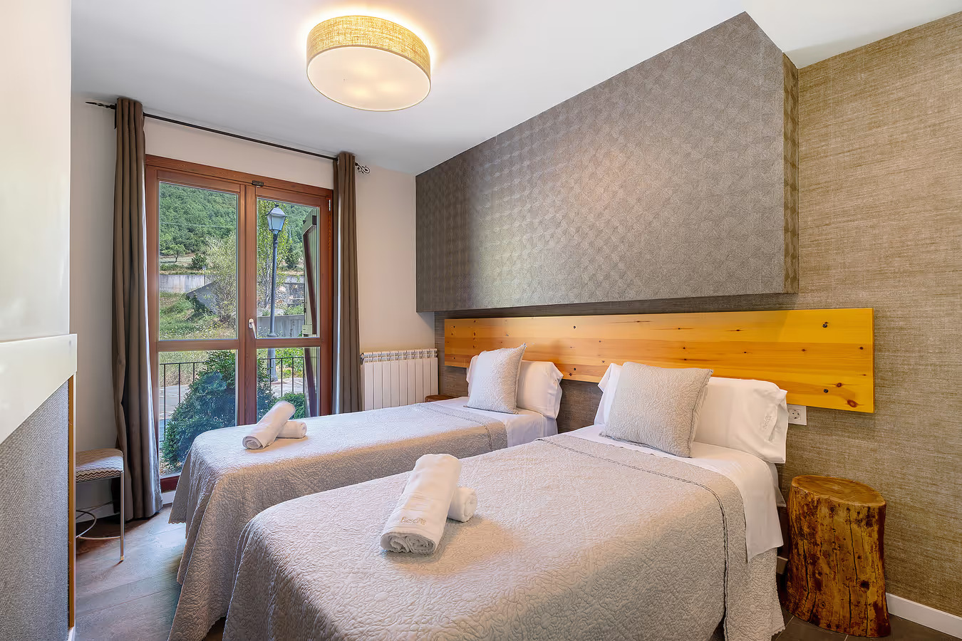 Dormitorio con dos camas individuales y cabecero de madera