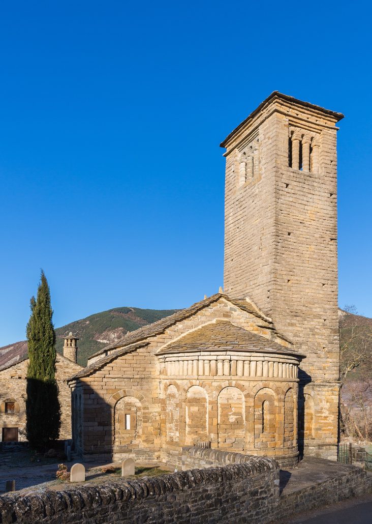Iglesia de San Pedro de Lárrede, con su torre cuadrada y el ábside decorado
